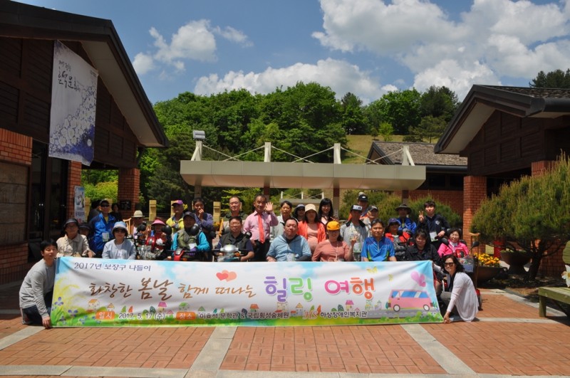 보장구 장애인 나들이에 참석한 모든 분들과 현수막(화장한 봄날 함께 떠나는 힐링 여행)을 앞에 놓고 전체 기념사진을 찍고 있는 모습