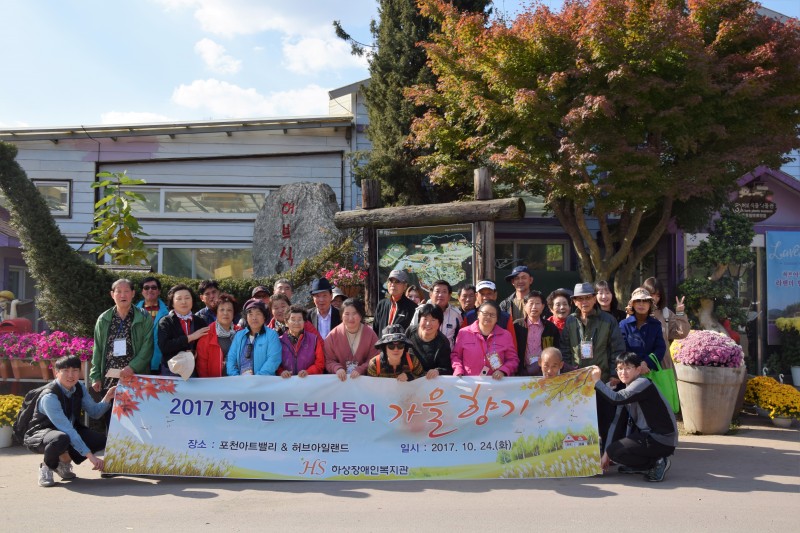 포천허브아일랜드내 꽃밭을 배경으로 나들이 참가자 전원이 현수막을 들고 있다.