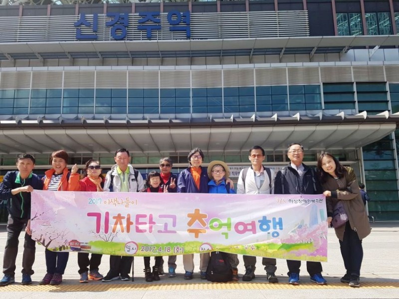 신경주역 앞에서 현수막을 들고 참가자 단체사진을 찍고 있음.