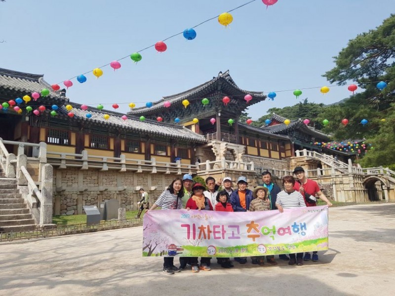 경주불국사 앞에서 현수막을 들고 단체사진을 찍고 있음.