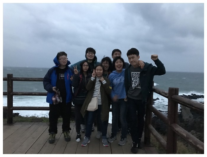 자기결정훈련 프로그램 캠프 참여자들이 제주도 바다를 배경으로 기념사진을 찍고 있는 모습