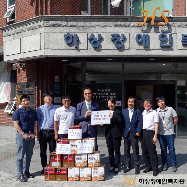 서울강남우체국에서 기부한 물품과 함께 김호식 관장과 강남우체국 직원일동이 함께 기념촬영하는 모습입니다.